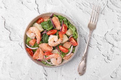Delicious pomelo salad with shrimps served on white textured table, flat lay