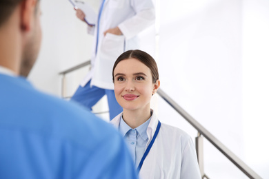 Female doctor talking to colleague on staircase in clinic