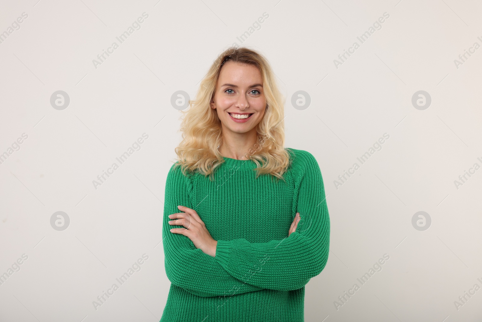 Photo of Happy woman in stylish warm sweater on white background