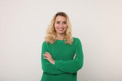 Happy woman in stylish warm sweater on white background