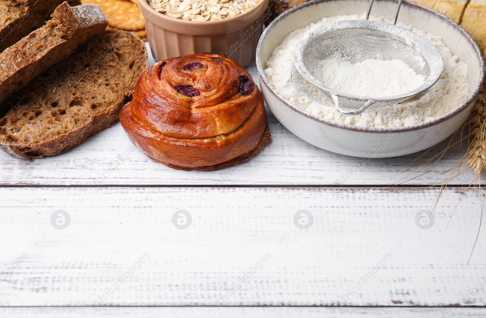 Photo of Different gluten free products on white wooden table, space for text