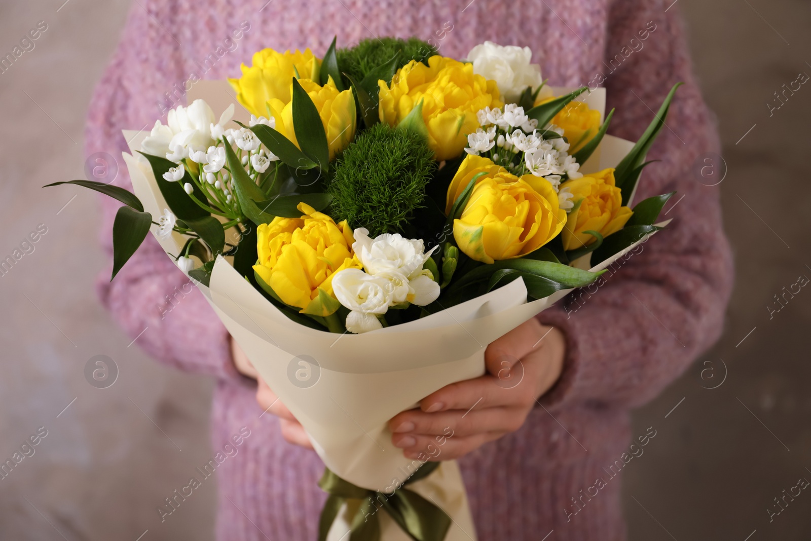 Photo of Woman with bouquet of beautiful tulips on beige background
