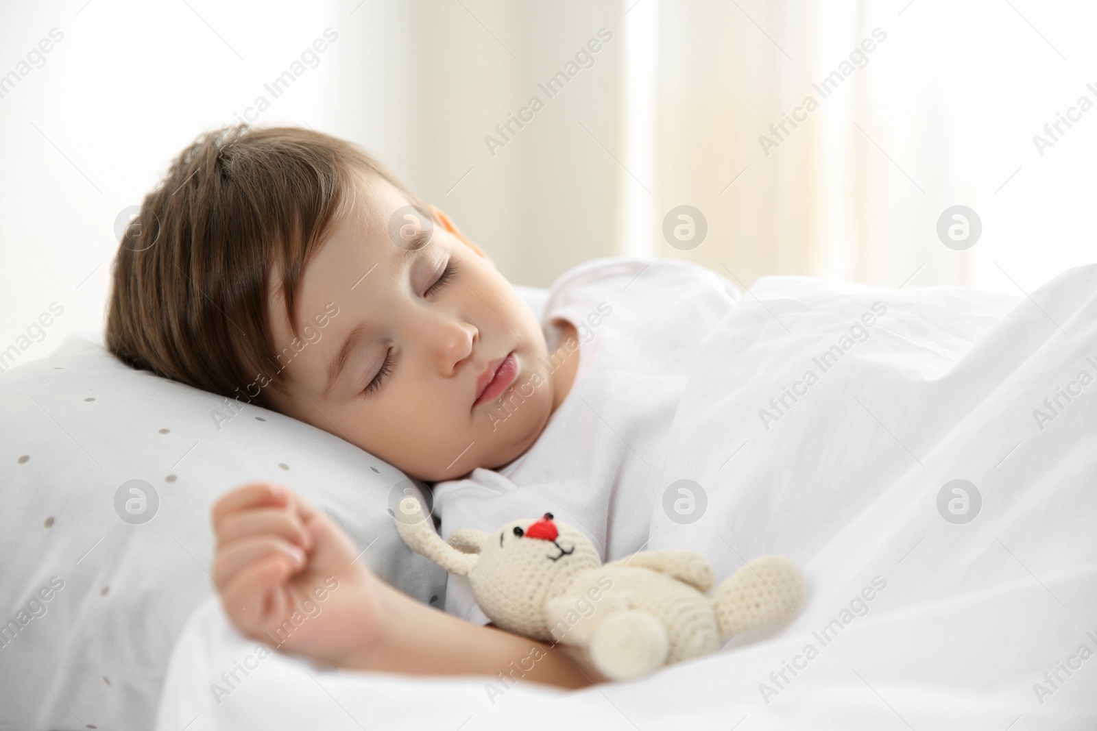 Photo of Cute little baby sleeping with toy at home. Bedtime