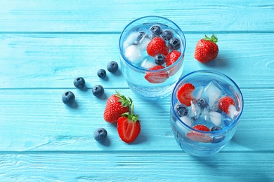 Photo of Natural lemonade with berries in glasses on wooden table