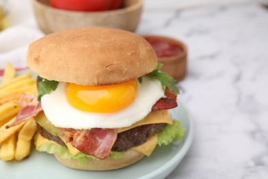 Delicious burger with fried egg and french fries served on white marble table, closeup. Space for text