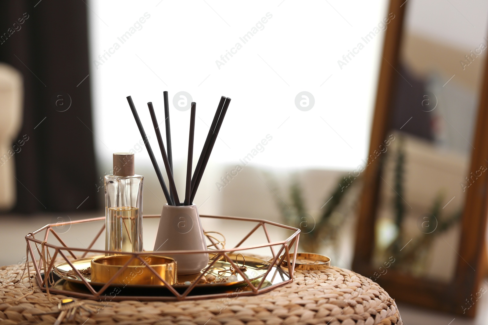 Photo of Composition with stylish accessories and interior elements on wicker pouf indoors