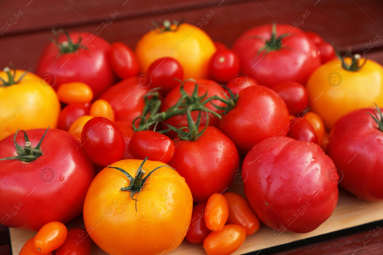 Photo of Many fresh tomatoes on wooden surface, closeup