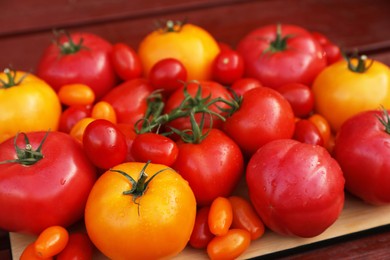 Photo of Many fresh tomatoes on wooden surface, closeup