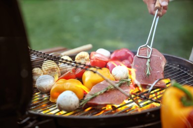 Image of Man cooking food on barbecue grill outdoors, closeup