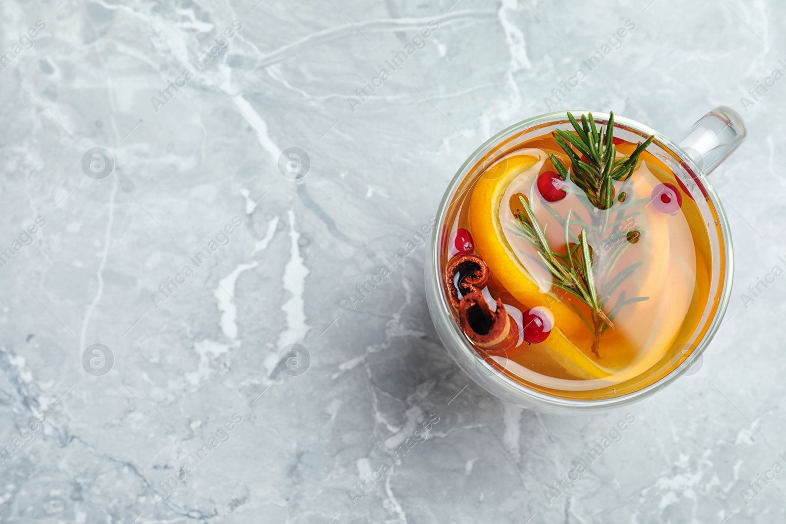 Photo of Aromatic mulled wine on grey marble table, top view. Space for text