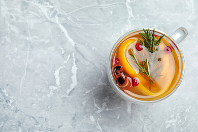 Photo of Aromatic mulled wine on grey marble table, top view. Space for text