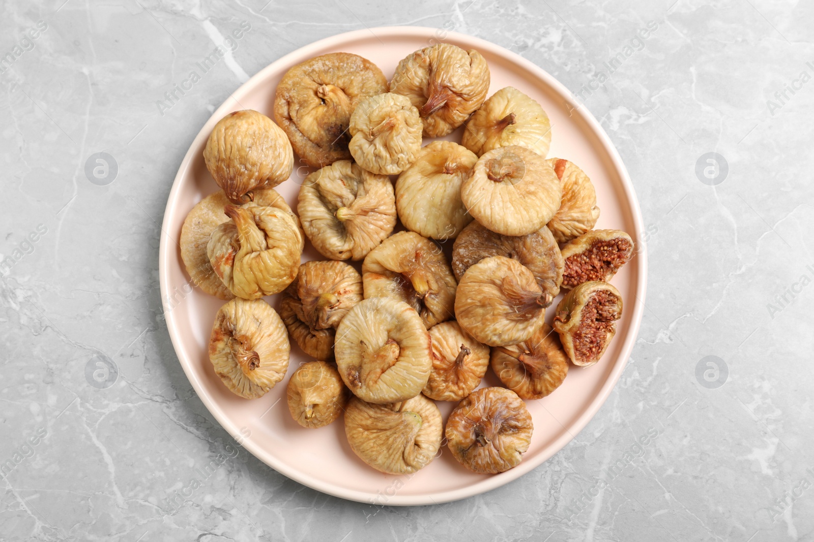 Photo of Tasty dried figs on light grey marble table, top view