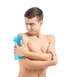 Young man applying cold compress to shoulder on white background