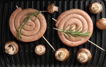 Photo of Homemade sausages, rosemary and mushrooms on electric grill, top view