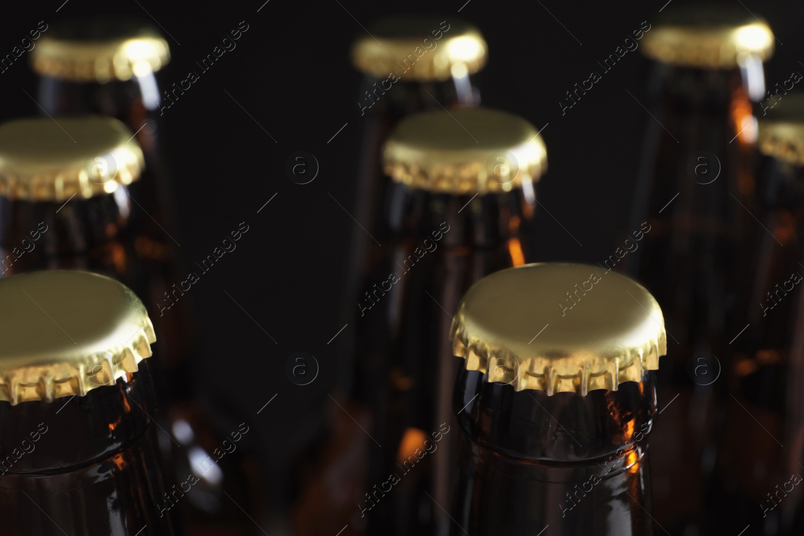 Photo of Many bottles of beer on dark background, closeup view