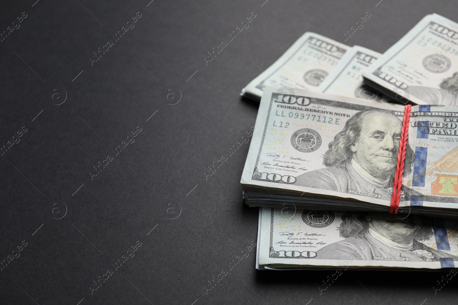 Photo of Many dollar banknotes on black background, closeup. Space for text