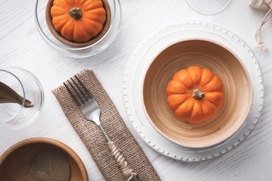 Autumn table setting with pumpkins on white wooden background, flat lay