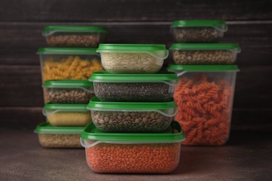 Photo of Plastic containers filled with food products on brown table