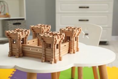 Wooden fortress on white table indoors. Children's toy