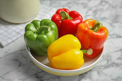 Bowl with ripe paprika peppers on table