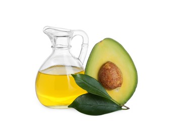 Photo of Jug with oil, green leaves and fresh cut avocado isolated on white
