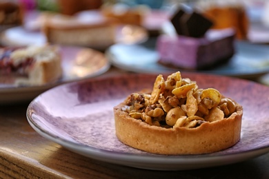 Photo of Plate with delicious cake on wooden table