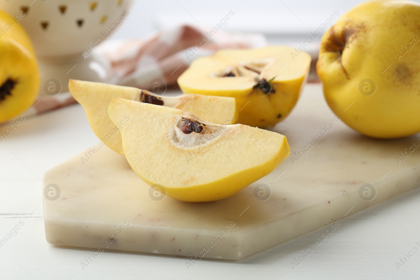 Photo of Tasty ripe quinces on white wooden table, closeup