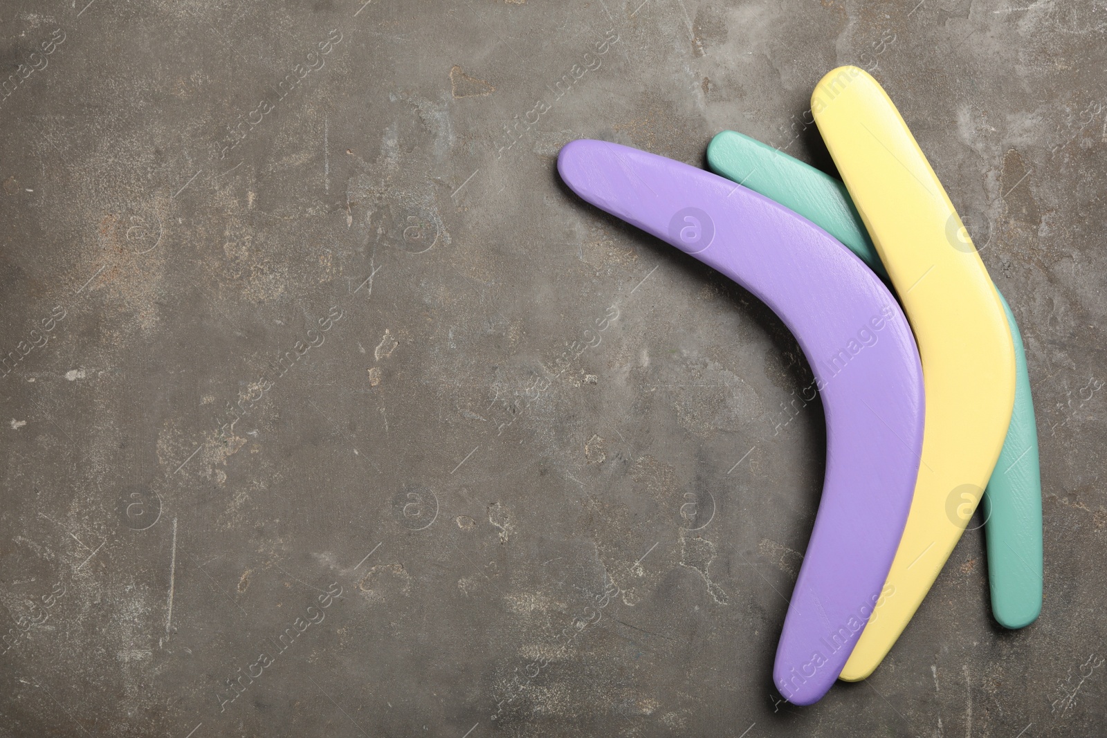 Photo of Boomerangs on grey stone background, flat lay. Space for text