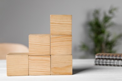 Photo of Wooden cubes on white table. Management concept