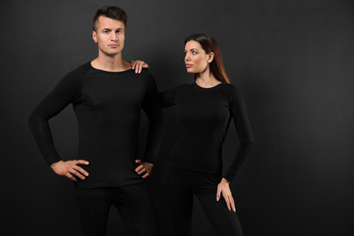 Couple wearing thermal underwear on black background