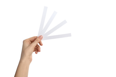 Woman holding perfume testing strips on white background, closeup