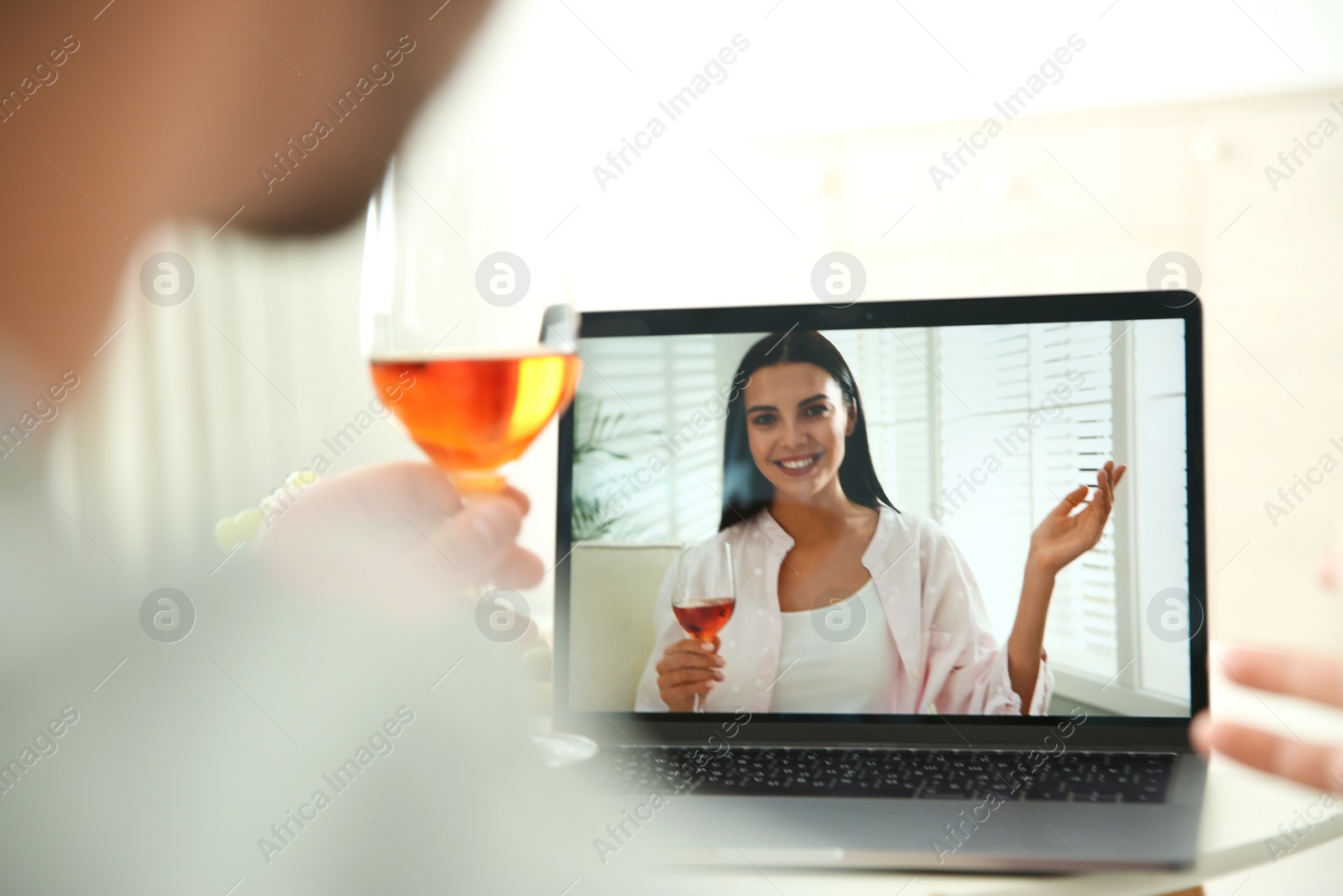 Photo of Friends drinking wine while communicating through online video conference at home. Social distancing during coronavirus pandemic