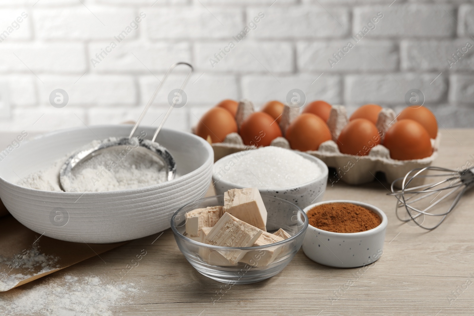 Photo of Flour, leaven and different ingredients on white wooden table. Cooking yeast cake