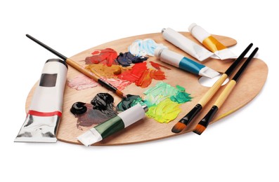 Photo of Wooden palette with oil paints and brushes on white background