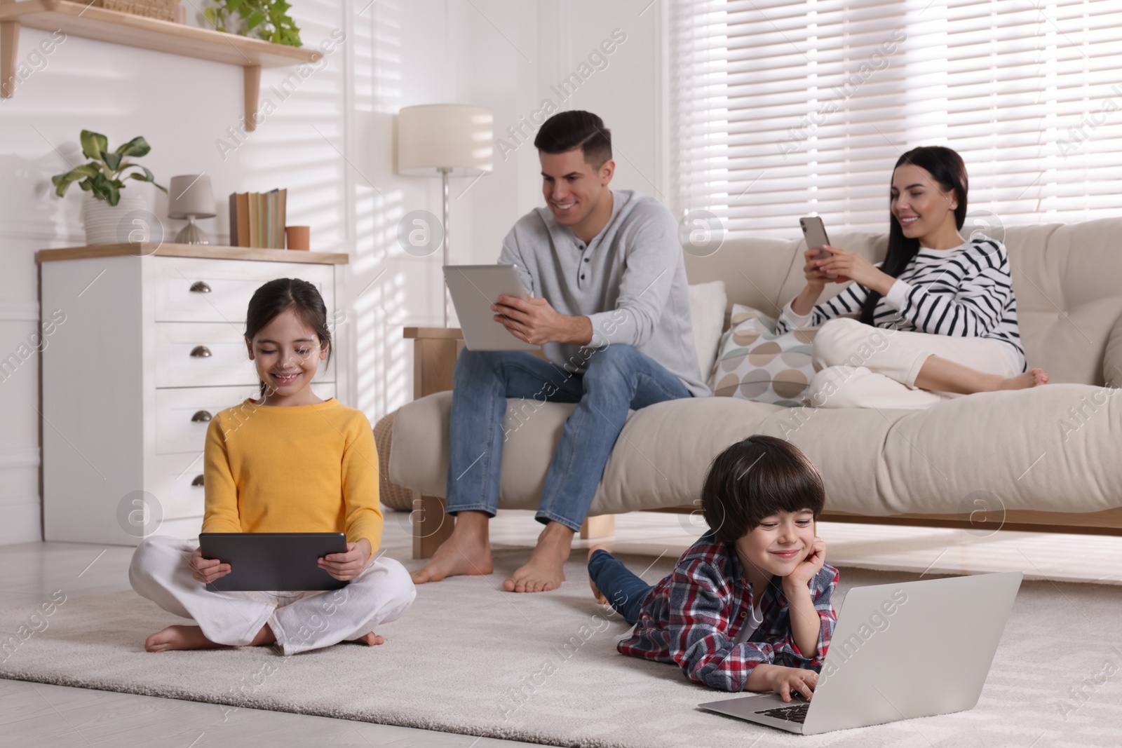 Photo of Internet addiction. Family with different gadgets in living room