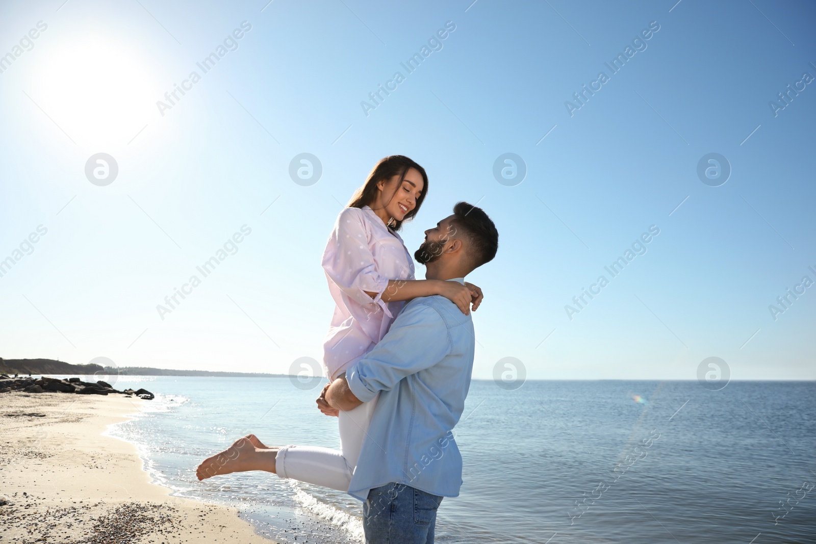 Photo of Happy young couple on beach near sea. Honeymoon trip