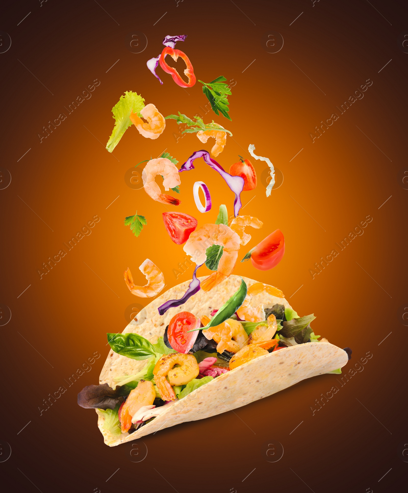 Image of Delicious tacos. Ingredients falling into tortilla on dark orange background