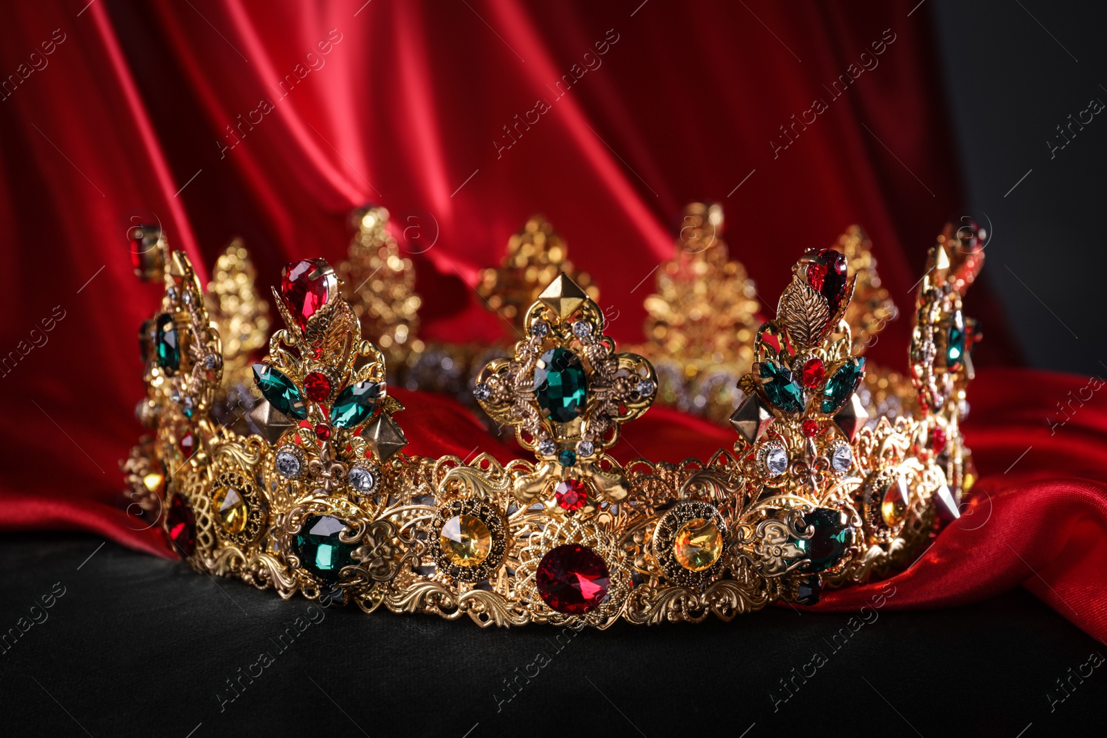 Photo of Beautiful golden crown with gems on black pillow