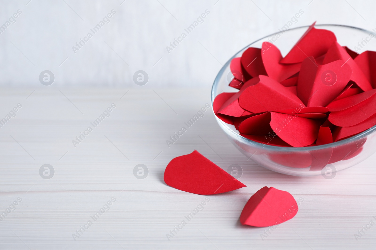 Photo of Red paper hearts on white wooden table. Space for text
