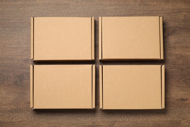 Photo of Closed cardboard boxes on wooden floor, flat lay. Packaging goods