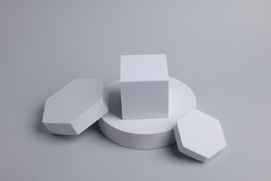 Photo of Scene with podium for product presentation. Figures of different geometric shapes on light grey background