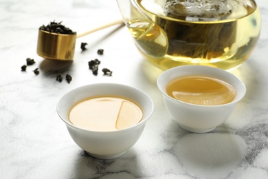 Cups of Tie Guan Yin oolong tea on marble table