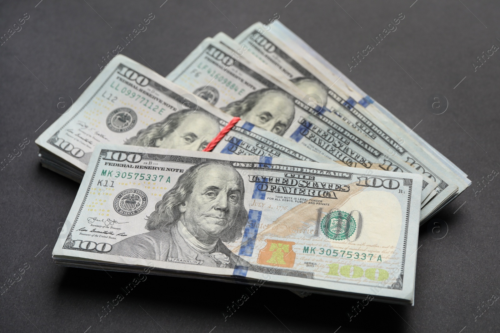 Photo of Many dollar banknotes on black background, closeup. American national currency