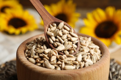 Raw peeled sunflower seeds in wooden bowl, closeup