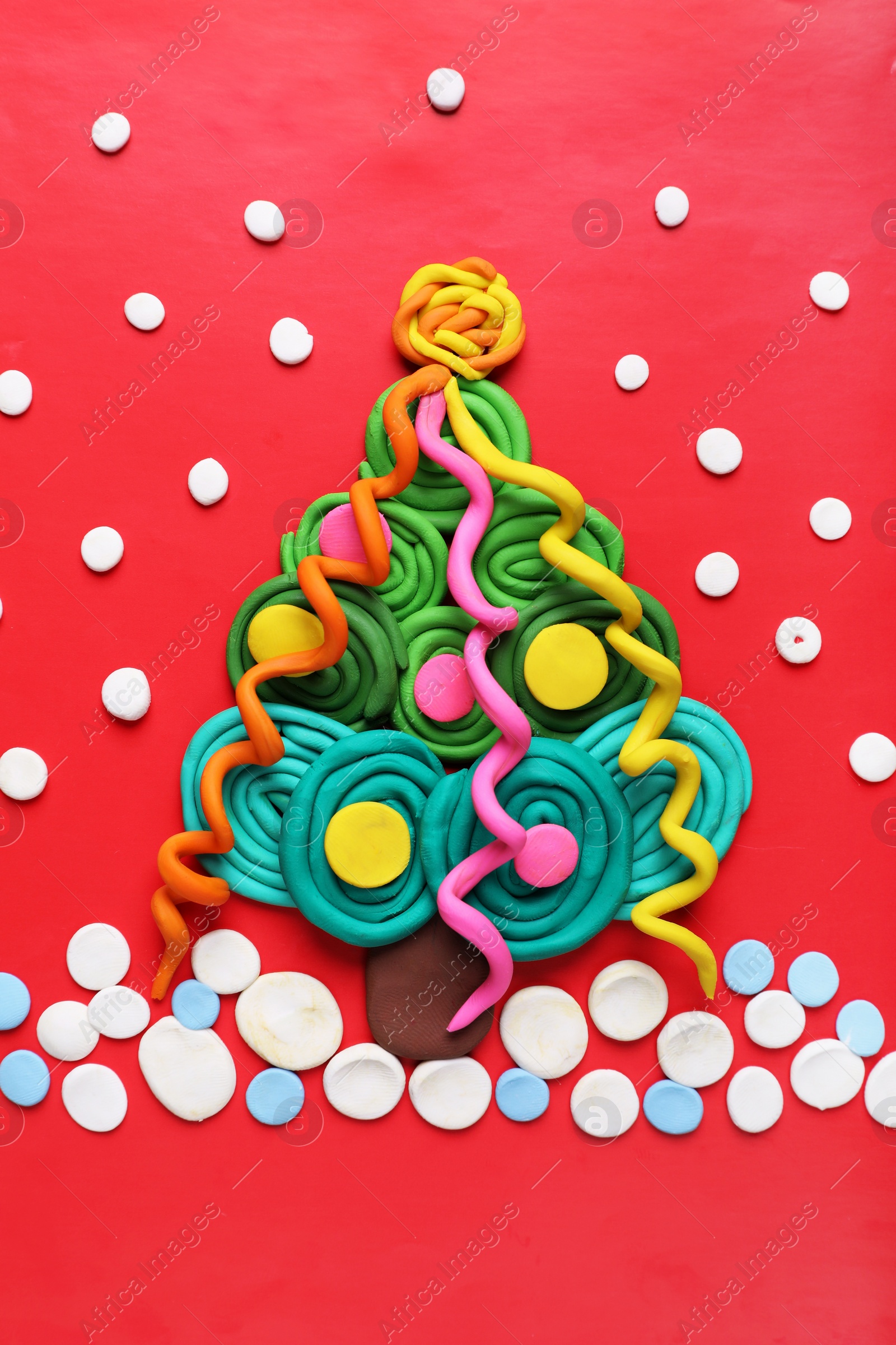 Photo of Plasticine Christmas tree and snow on red background, flat lay