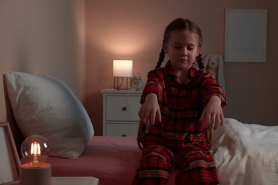 Girl in pajamas sleepwalking indoors at night