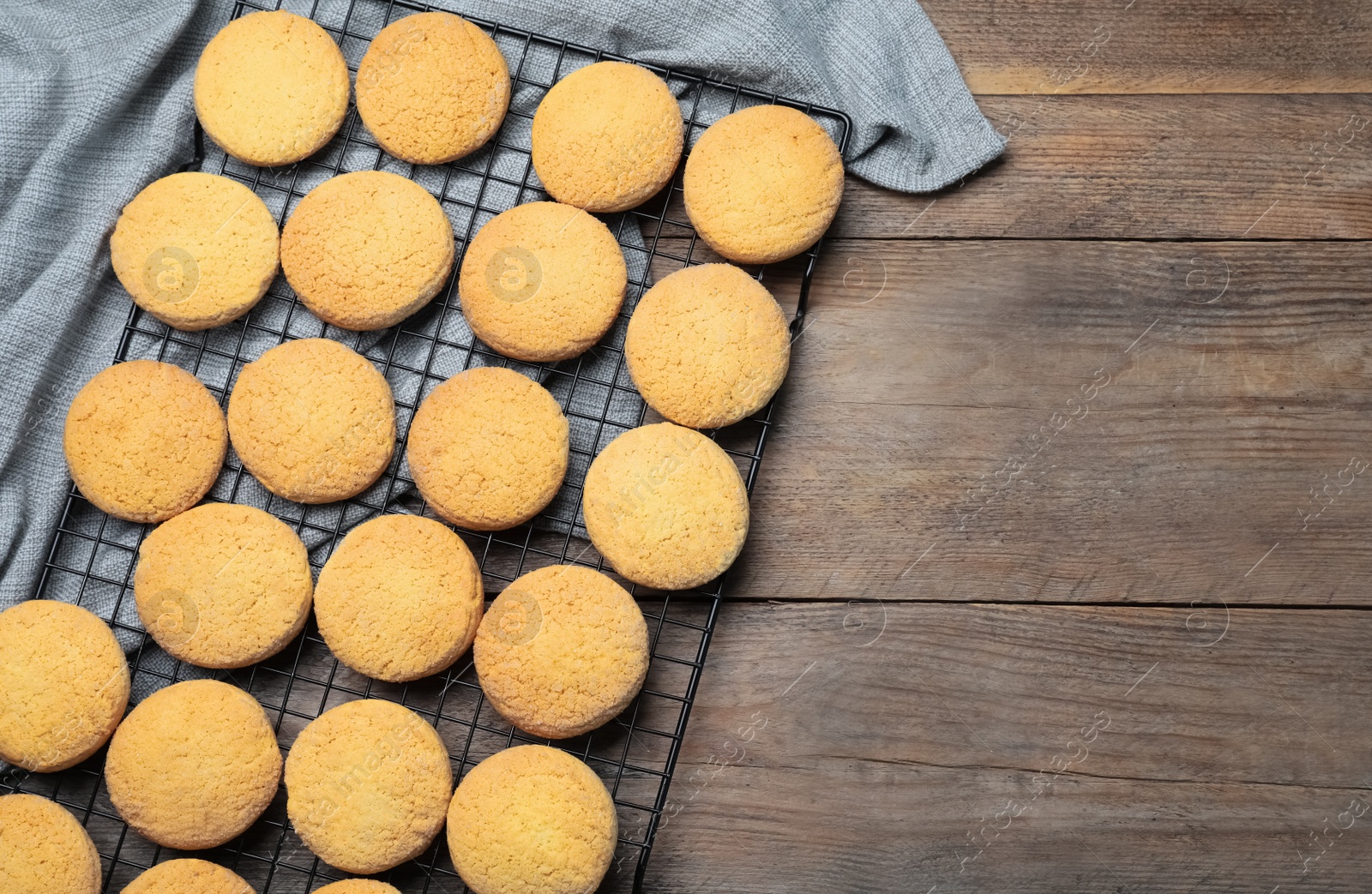 Photo of Many tasty sugar cookies on wooden table, top view. Space for text