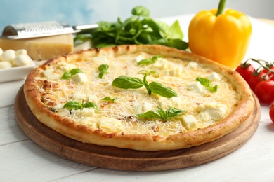 Delicious pizza with cheese and basil on table