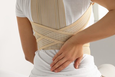 Closeup view of woman with orthopedic corset indoors