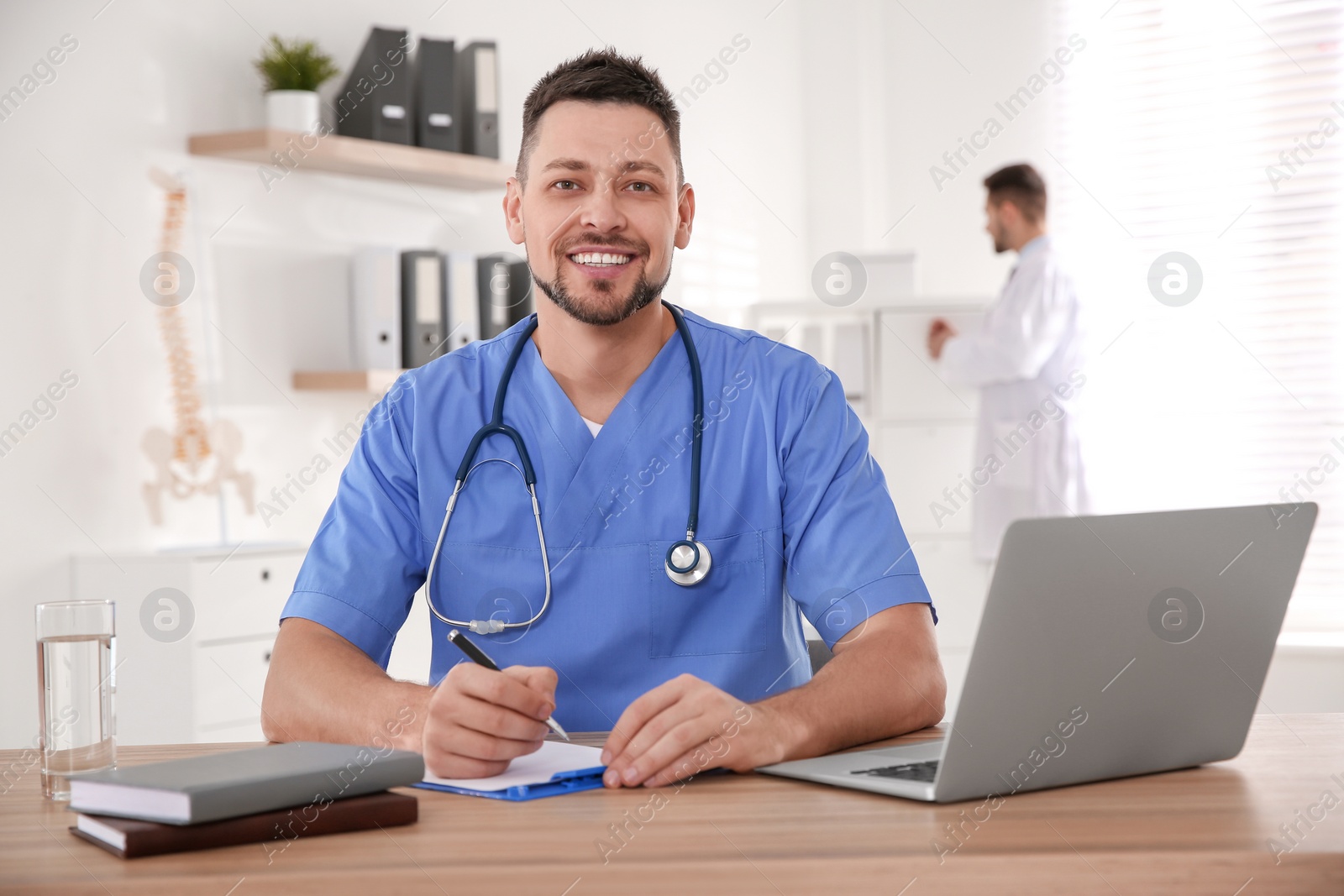 Photo of Portrait of male doctor at table in modern clinic